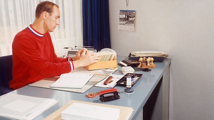 Willi Schulz sitzt im März 1967 an seinem Schreibtisch - an der Wand ein Wimpel mit dem Aufdruck World Cup. 