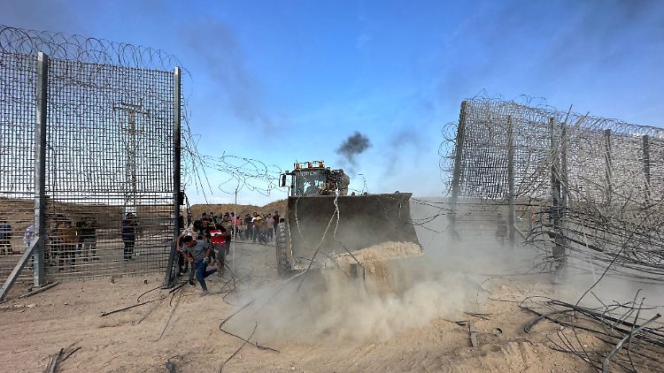 Palästinenser durchbrechen einen Zaun am Gazastreifen.