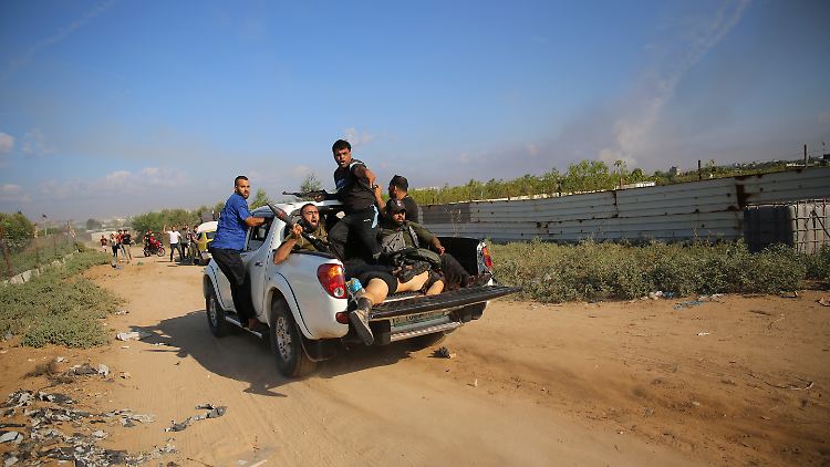 Hamas-Anhänger fahren mit einer leblosen Person zurück in den Gazastreifen. Die Terroristen haben zahlreiche Zivilisten und Soldaten als Geiseln genommen und auch Leichen von Getöteten verschleppt.