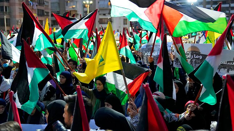 Anhänger der Hisbollah-Miliz schwenken zur Feier des Angriffs auf Israel durch die Hamas Fahnen. 