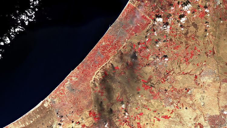 Dunkle Rauchschwaden über dem israelischen Grenzgebiet: Der Gazastreifen (hier in einer Falschfarbenaufnahme: Vegetation erscheint in Rot) am Tag des Großangriffs.