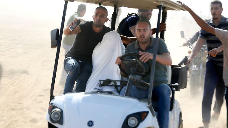 Palästinenser transportieren am Samstag einen israelischen Zivilisten aus der Siedlung Kfar Azza in den Gazastreifen.