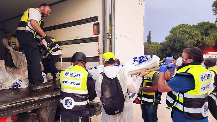 Leichensack um Leichensack laden die Helfer vom Rettungsdienst Zaka auf die LKW.