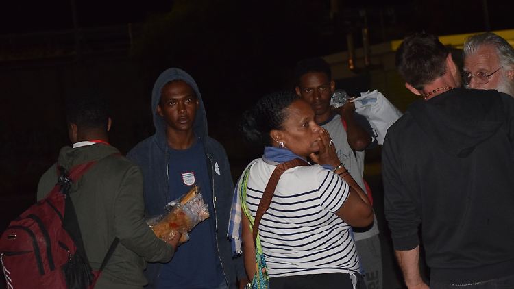 Migranten in Ventimiglia warten auf ein Abendessen.