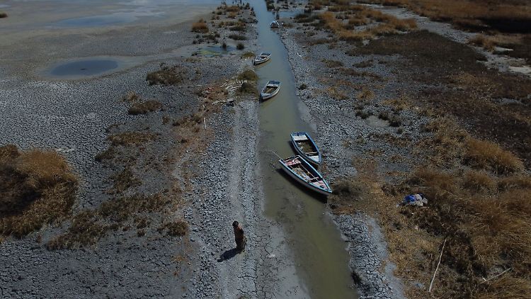 Boote stehen an einem fast ausgetrockneten Ufer des Titicacasees. Aufgrund niedriger Niederschläge und großer Hitze ist der Pegel des Titicacasees in Südamerika unter seinen historischen Tiefstand gesunken.