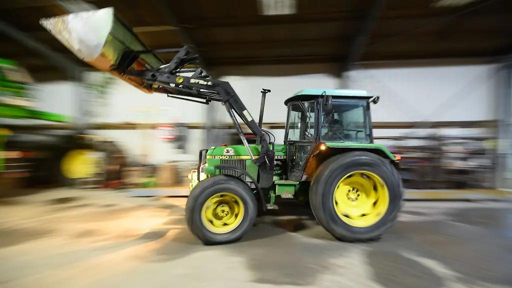 Ein-Landwirt-faehrt-mit-seinem-Radlader-in-eine-Fahrzeughalle-Bayern-stellt-sich-gegen-Kuerzungen-bei-Agrarsubventionen