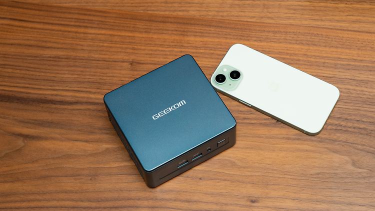 Im Vergleich mit einem iPhone 15 sieht man, wie kompakt der Geekom Mini IT13 ist.