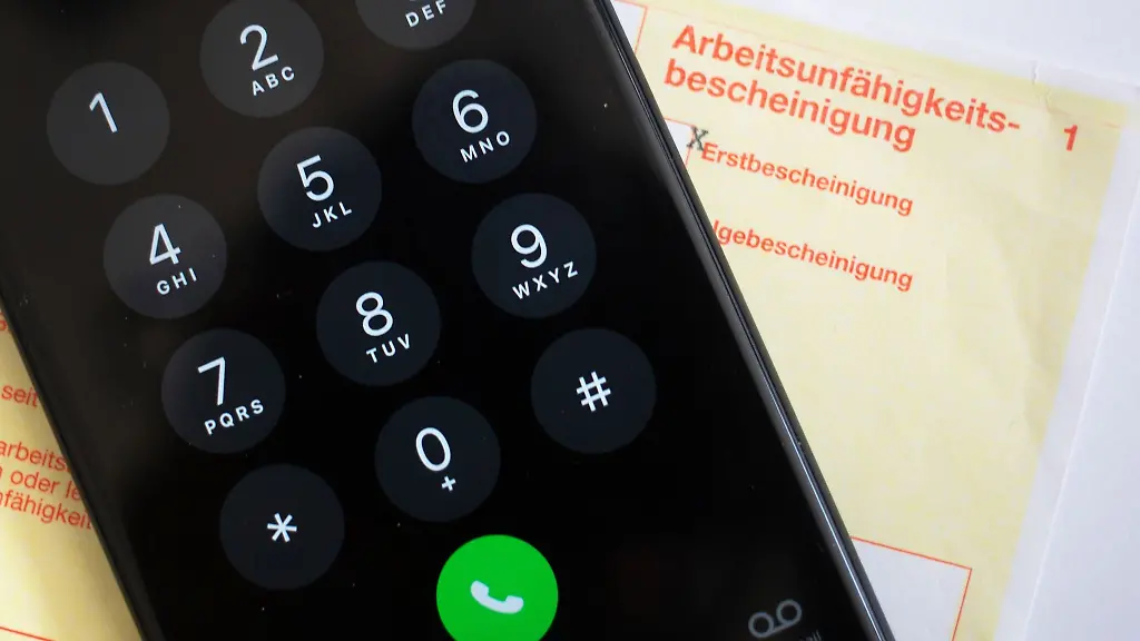 Ein-Smartphone-liegt-auf-einer-Arbeitsunfaehigkeitsbescheinigung