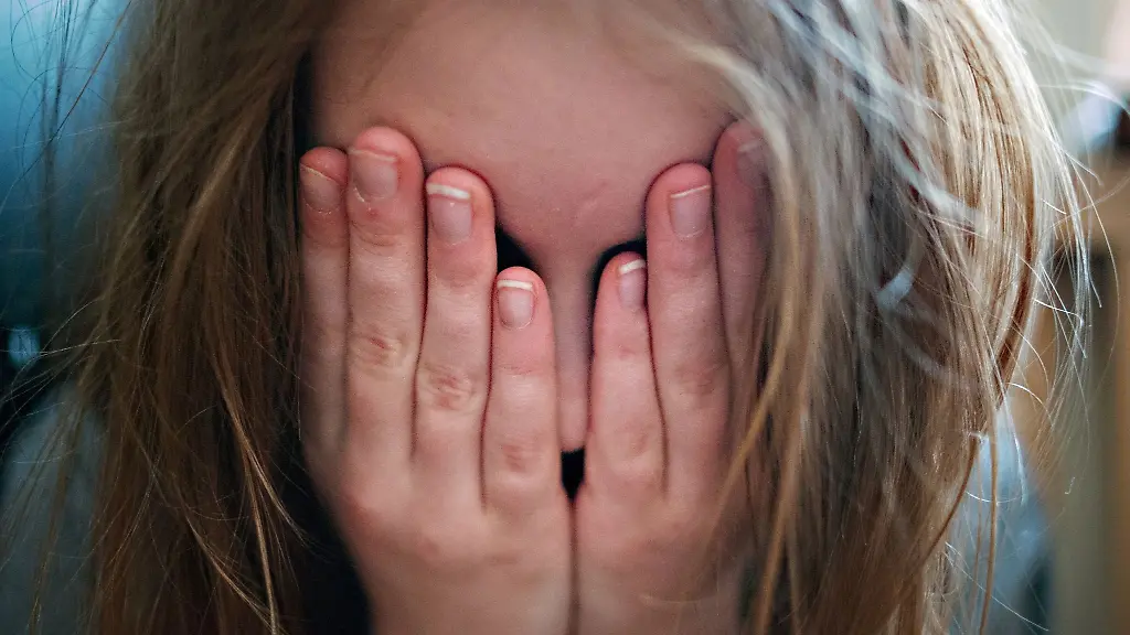 Ein-junges-Maedchen-haelt-sich-die-Haende-vor-ihr-Gesicht