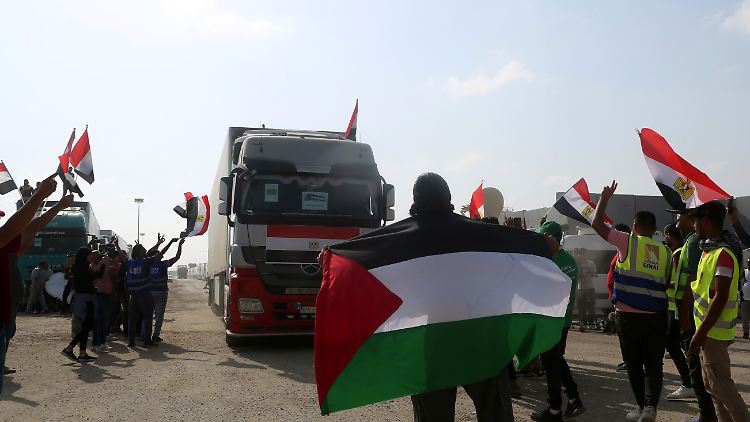 Freiwillige schwenken palästinensische und ägyptische Flaggen vor einem Lastwagen, der humanitäre Hilfe für die Menschen im Gazastreifen transportiert.
