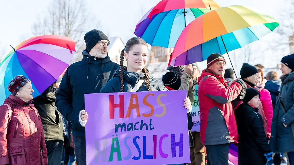 Menschen-halten-Schirme-in-Regenbogenfarben-bei-der-Demonstration-Bunte-Zukunft-statt-braunes-Hinterland