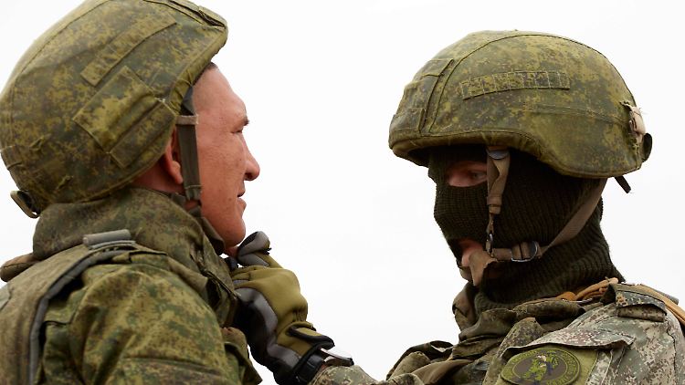 Ein russischer Ausbilder (r.) in Stawropol kleidet einen russischen Rekruten ein.