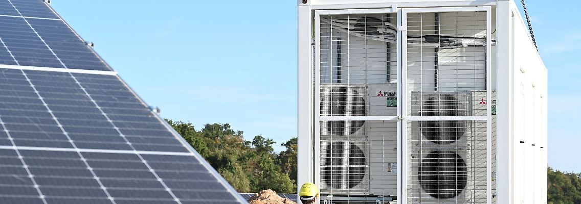 An einem Solarpark werden zwei Batteriespeicher angeliefert.