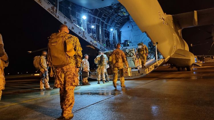 Bundeswehrsoldaten gehen auf dem Fliegerhorst Wunstorf zu ihrem Flugzeug.