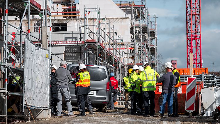 Einsatzkräfte des Zolls befragen Arbeiter auf einer Baustelle, ob eine illegale Beschäftigung besteht oder ob eine Arbeitserlaubnis der Arbeitnehmer vorliegt.