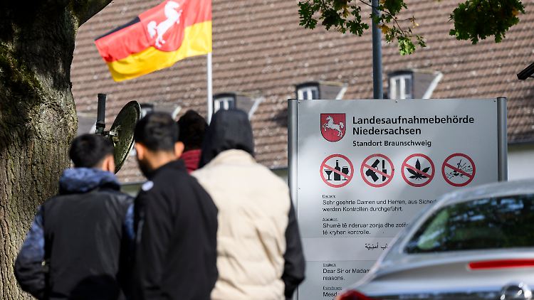 Flüchtlinge warten vor der Landesaufnahmebehörde Niedersachsen am Standort Braunschweig.
