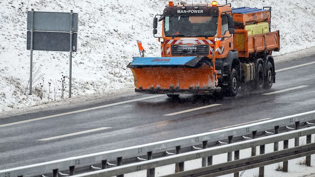 Ein-Fahrzeug-des-Winterdienstes-faehrt-waehrend-es-schneit