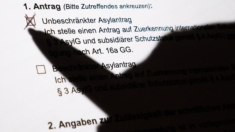 Der Schatten eines Kugelschreibers zeichnet sich auf einem Asylerstantrag ab.