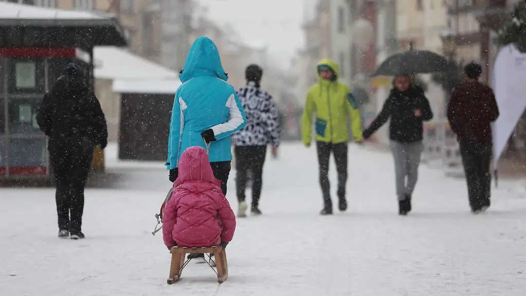 Personen-ziehen-einen-Schlitten-durch-das-Stadtzentrum-in-Muehlhausen