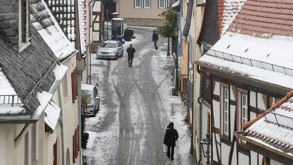 Passanten-gehen-durch-die-vereiste-Fussgaengerzone-der-Taunusgemeinde-Oberursel-bei-Frankfurt
