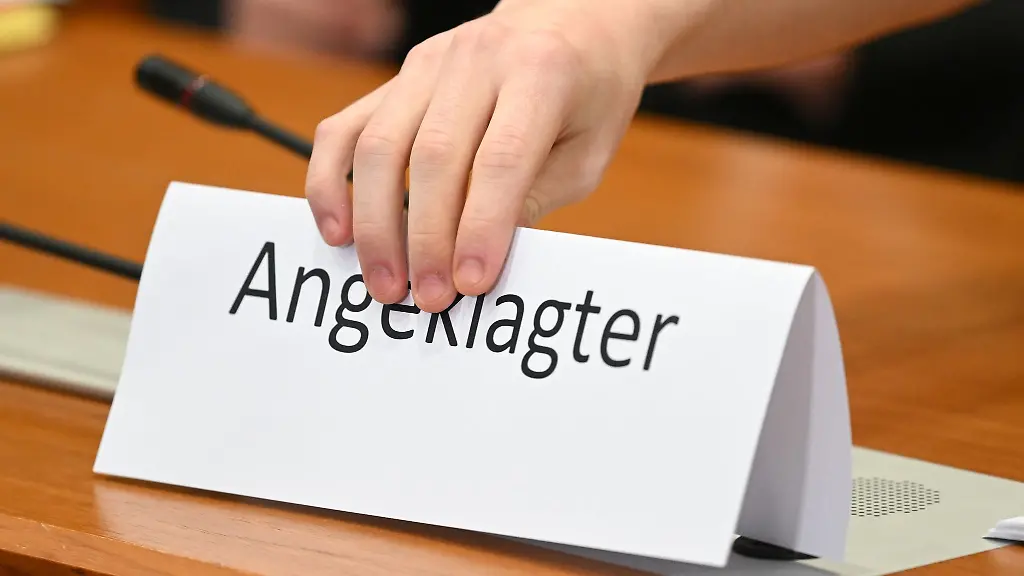 Ein-Schild-mit-der-Aufschrift-Angeklagter-wird-auf-die-Gerichtsbank-gestellt