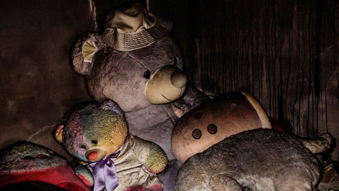 In einem Safe Room, der als Kinderzimmer genutzt wurde, sind Plüschtiere zurückgeblieben, schwarz von Ruß.