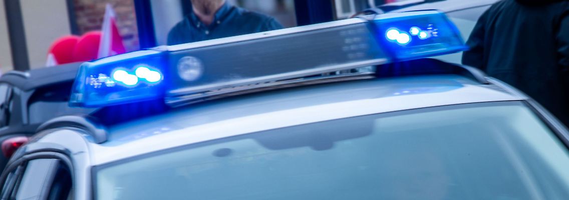 Ein Streifenwagen der Polizei ist mit Blaulicht im Einsatz.