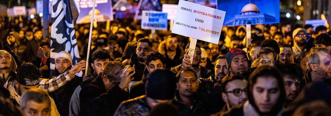 Schilder und Fotos werden gezeigt bei der Kundgebung "Gaza unter Beschuss - gemeinsam gegen das Unrecht".
