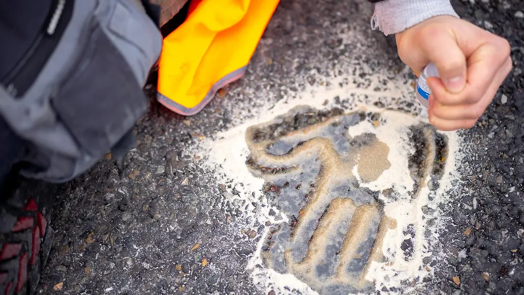 Der-Handabdruck-eines-Aktivisten-klebt-auf-der-Strasse