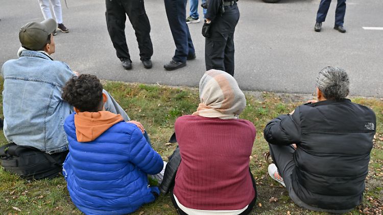 Unerlaubt eingereiste Migranten sitzen vor Beamten der Bundespolizei, nachdem sie nahe Forst (Lausitz) aufgegriffen wurden.