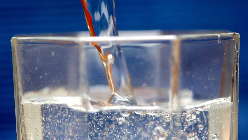 Mineralwasser-wird-in-ein-Wasserglas-gegossen