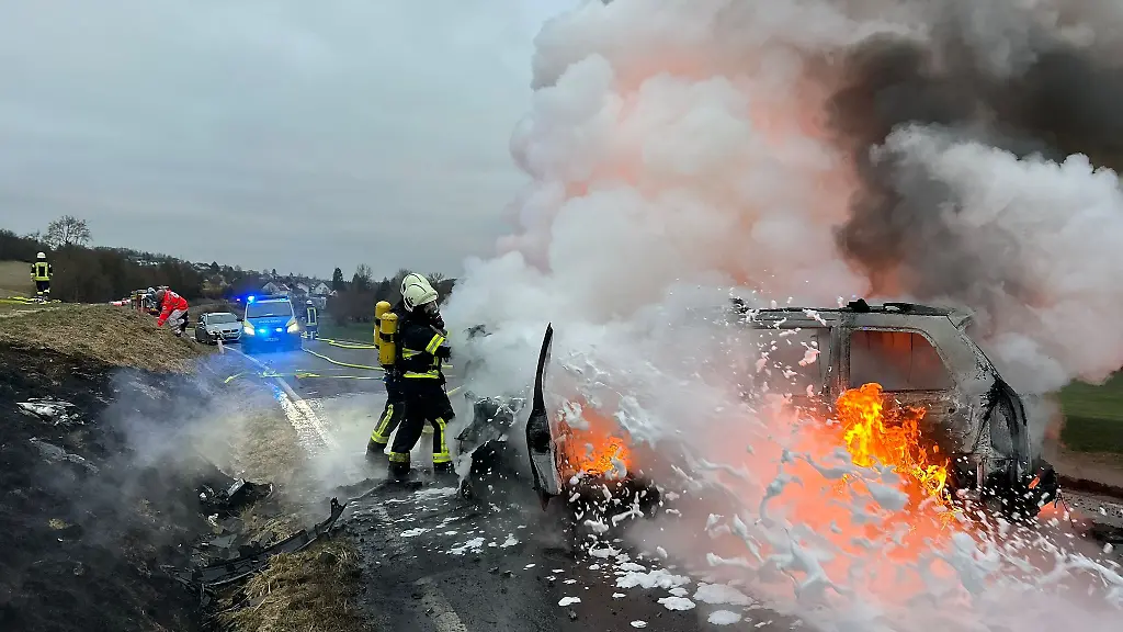 Einsatzkraefte-der-Feuerwehr-loeschen-brennende-Fahrzeuge