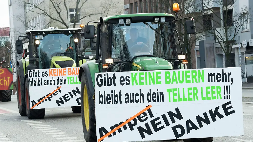 Landwirte-demonstrieren-mit-ihren-Treckern-vor-dem-Exerzierplatz-und-haben-Plakate-mit-der-Aufschrift-Gibt-es-keine-Bauern-mehr-bleibt-auch-dein-Teller-leer-und-Ampel-nein-danke-an-zwei-Treckern-angebracht