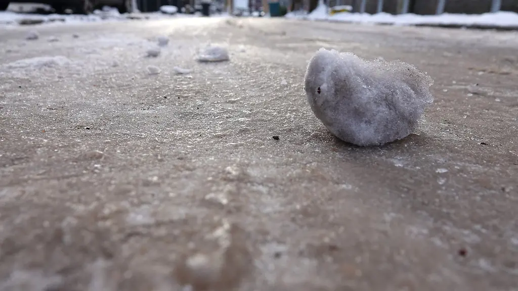Eisklumpen-liegen-auf-einer-vereisten-Strasse