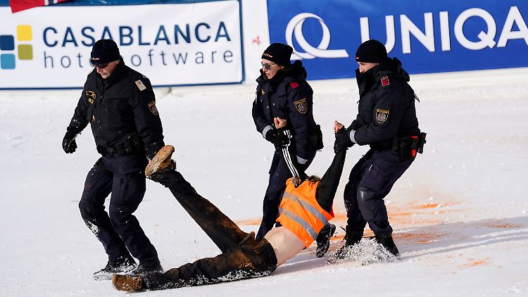 Die Polizisten tragen einen Aktivisten weg.