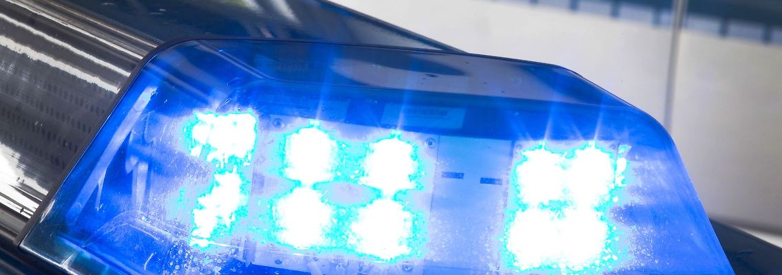Ein Blaulicht leuchtet während eines Einsatzes auf dem Dach eines Polizeiwagens.