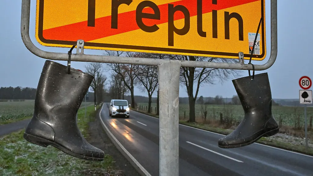Gummistiefel-als-Protest-der-Landwirte-ueber-die-geplanten-Kuerzungen-und-Streichungen-der-Bundesregierung-haengen-an-einem-Ortsschild
