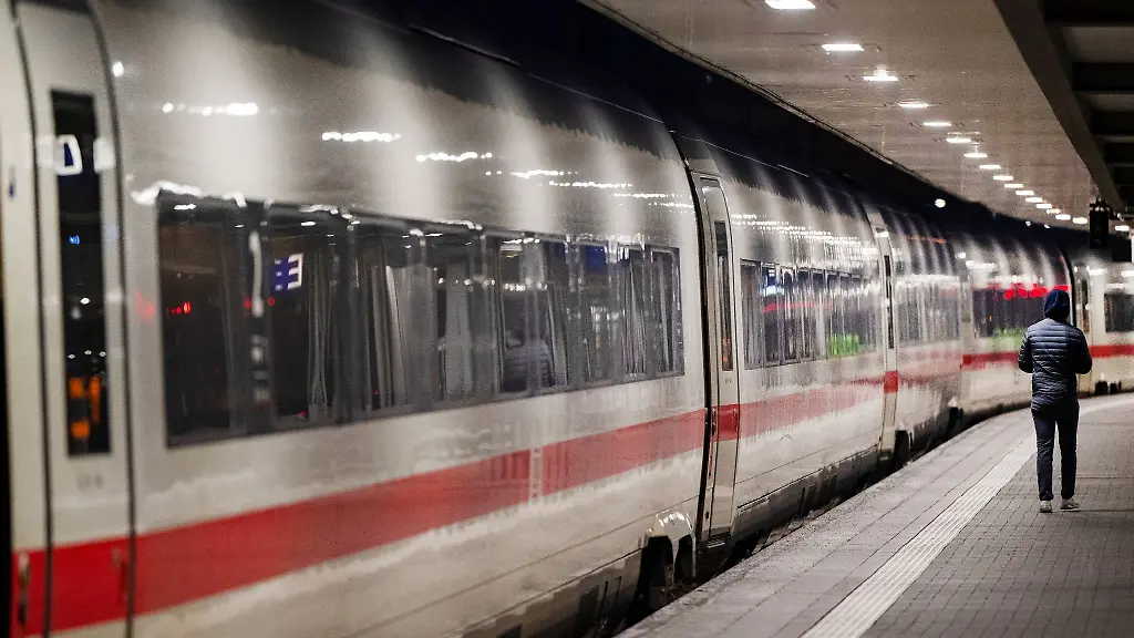 Ein-Bahnreisender-geht-am-Hauptbahnhof-in-Muenchen-einen-Bahnsteig-entlang