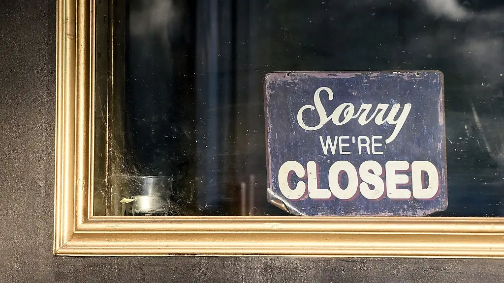 An-der-Tuer-eines-geschlossenen-Restaurants-haengt-ein-Schild-mit-der-Aufschrift-Sorry-we-re-closed