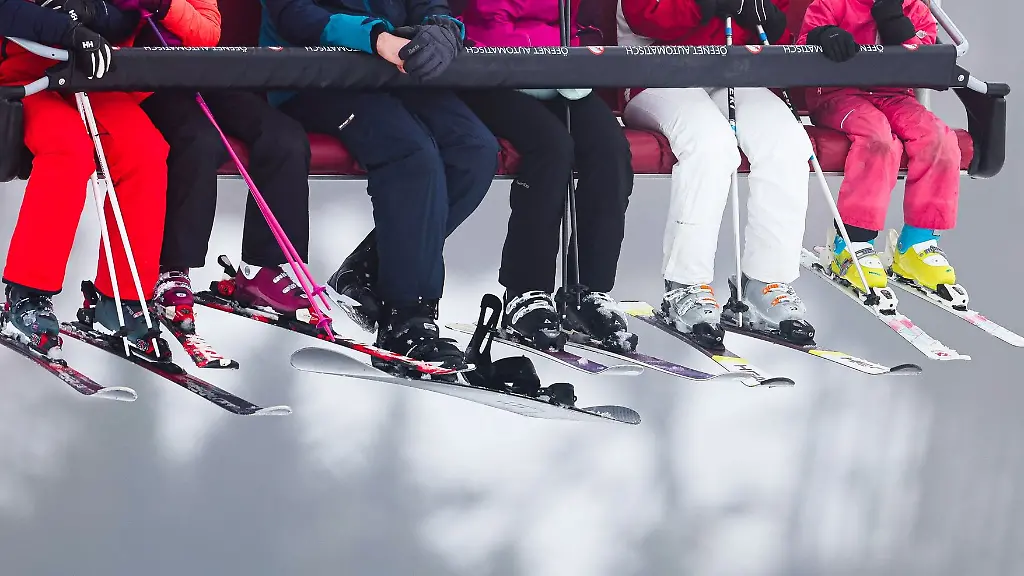 Skifahrer-sitzen-in-einem-Lift-auf-dem-Weg-zur-Skipiste