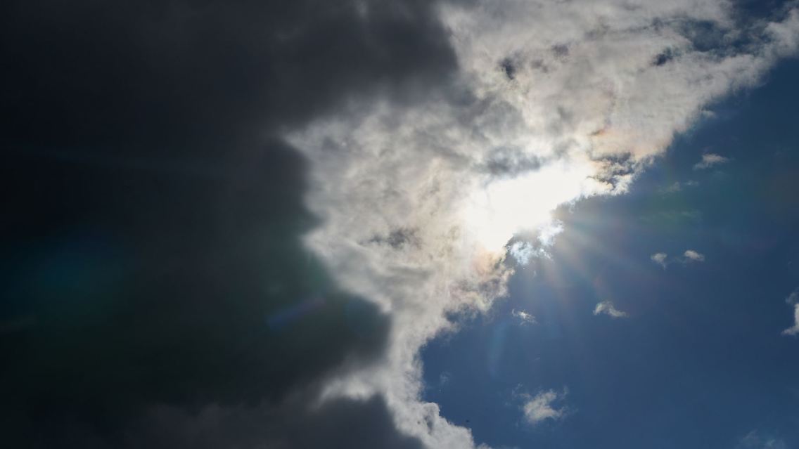 Die Sonne kommt hinter Regenwolken hervor.