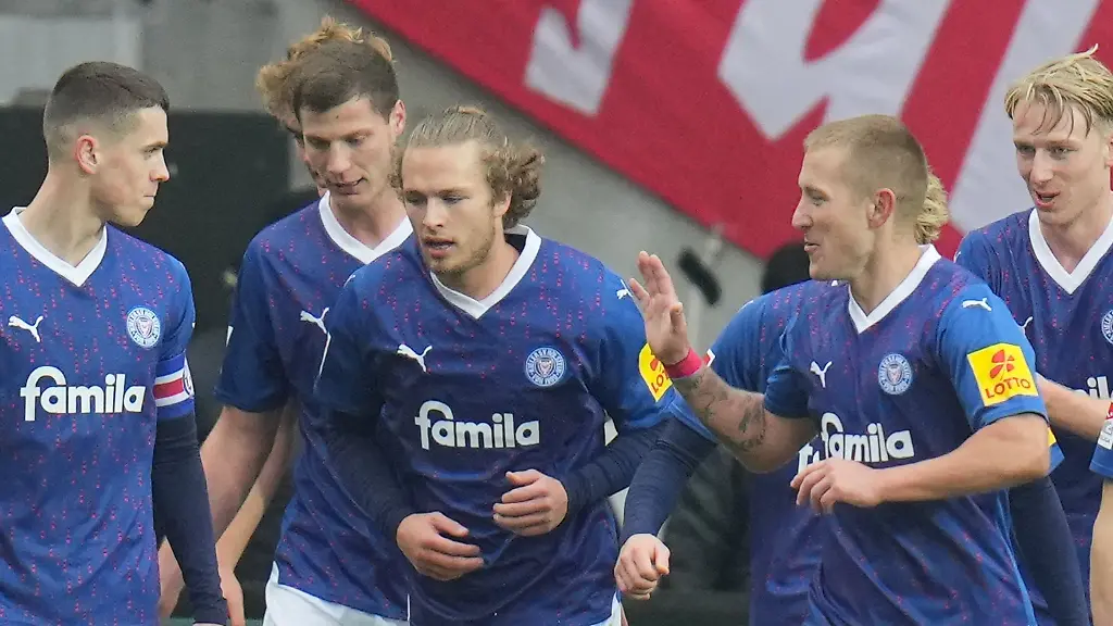 Jann-Fiete-Arp-3-v-l-und-Lewis-Holtby-2-v-r-jubeln-mit-ihrem-Team-im-Fritz-Walter-Stadion