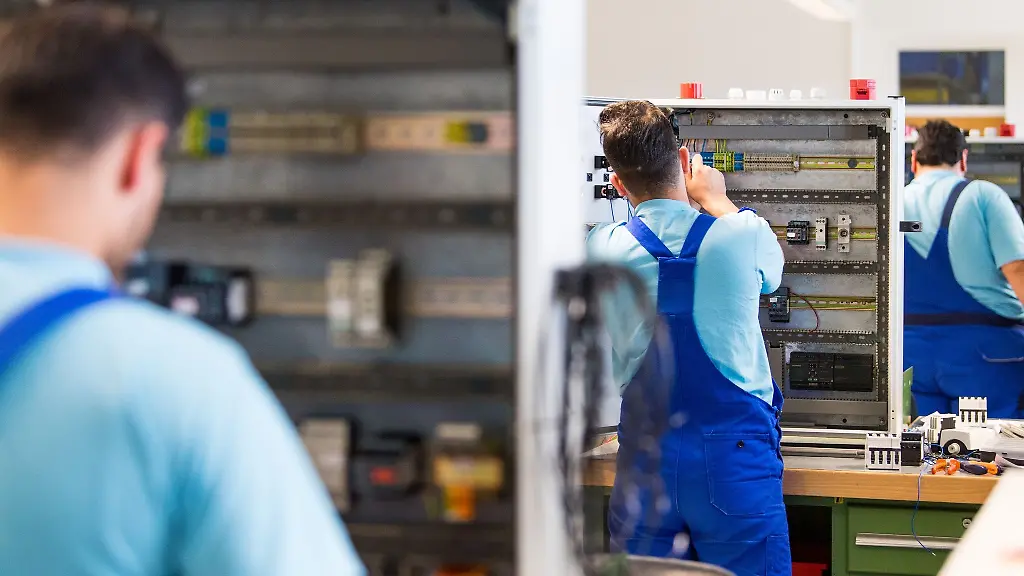 Drei-junge-Fluechtlinge-arbeiten-im-Ausbildungszentrum-der-Siemens-Professional-Education-an-der-Verdrahtung-eines-Schaltschranks