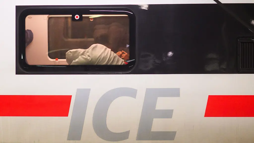 Ein-Fahrgast-liegt-mit-dem-Kopf-auf-einem-Tisch-in-einem-ICE-der-Deutschen-Bahn