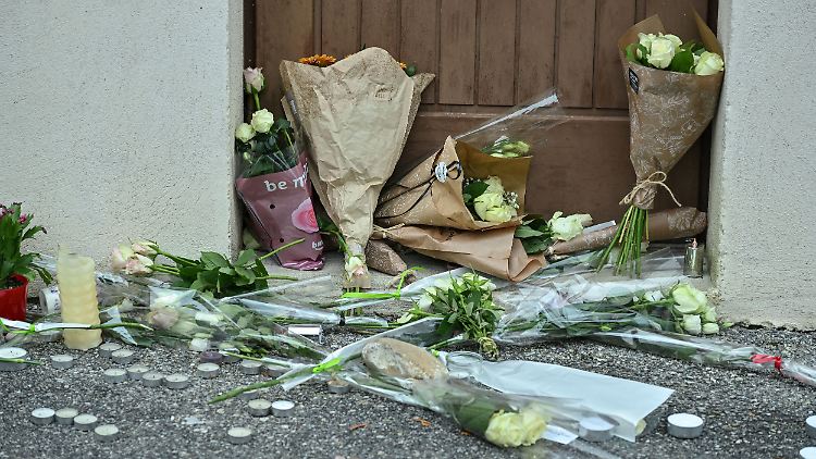 Menschen haben Blumen abgelegt vor der Festhalle in der Ortschaft Crépol, wo ein Teenager offenbar durch Messerstiche zu Tode kam.