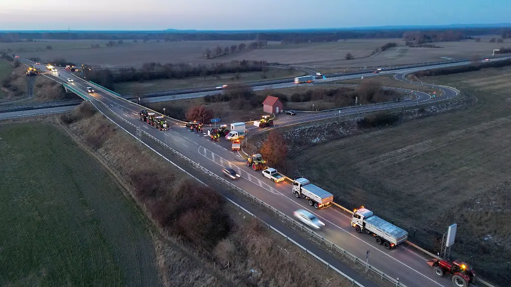 Speditionsunternehmer-mit-ihren-Lkw-Handwerker-und-Landwirte-mit-ihren-Traktoren-blockieren-am-Morgen-die-Auffahrt-auf-die-A12