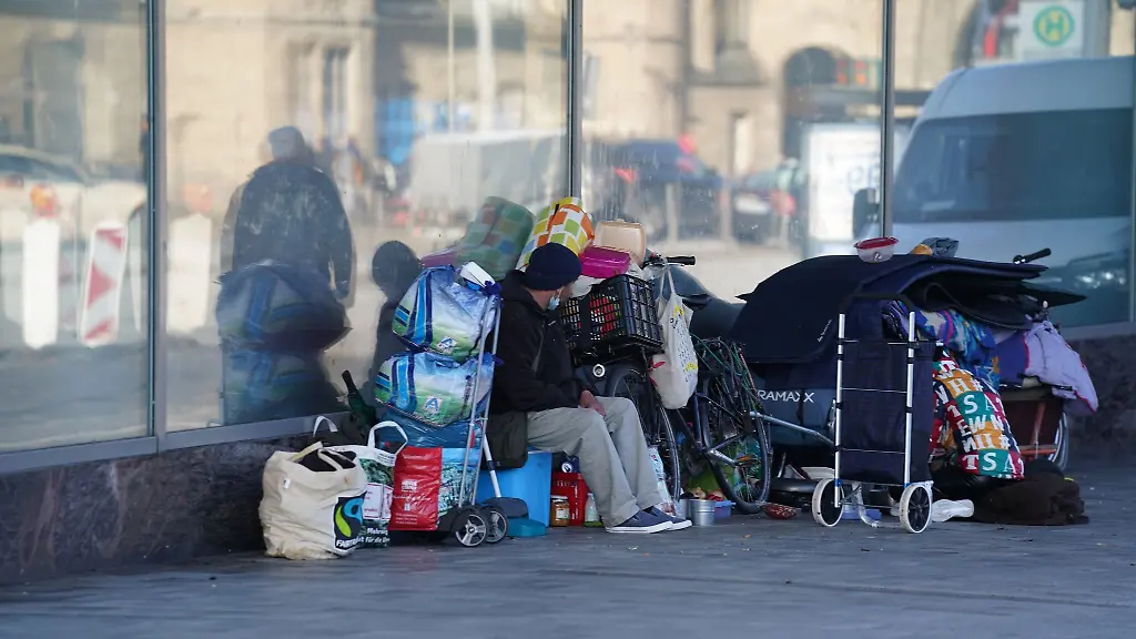 Obdachlose-sitzen-vor-einem-leerstehenden-Geschaeft-in-der-Innenstadt