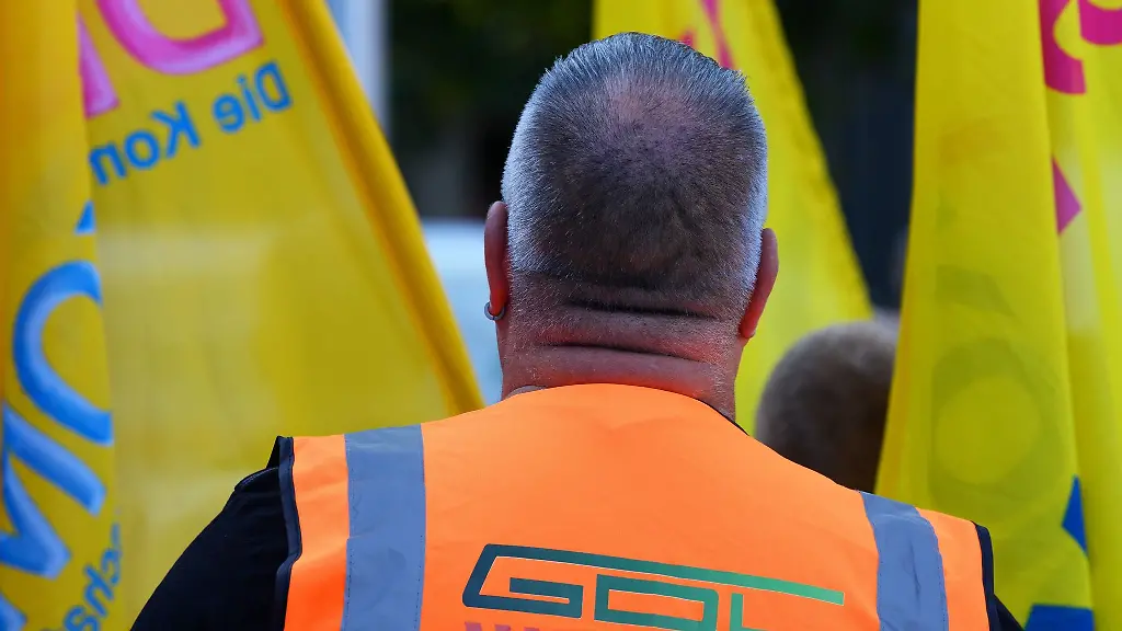 Waehrend-einer-Kundgebung-der-Gewerkschaft-Deutscher-Lokomotivfuehrer-GDL-vor-dem-Hauptbahnhof-traegt-ein-Teilnehmer-eine-orangefarbene-Weste-mit-der-Aufschrift-GDL