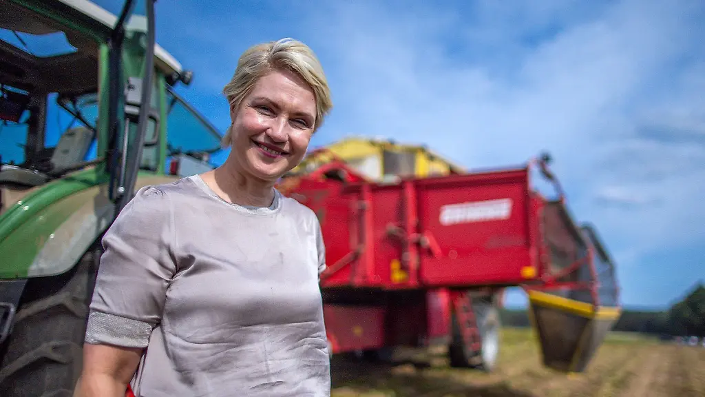 Manuela-Schwesig-SPD-Ministerpraesidentin-von-Mecklenburg-Vorpommern-steht-auf-einem-Kartoffelfeld-vor-einer-Erntemaschine