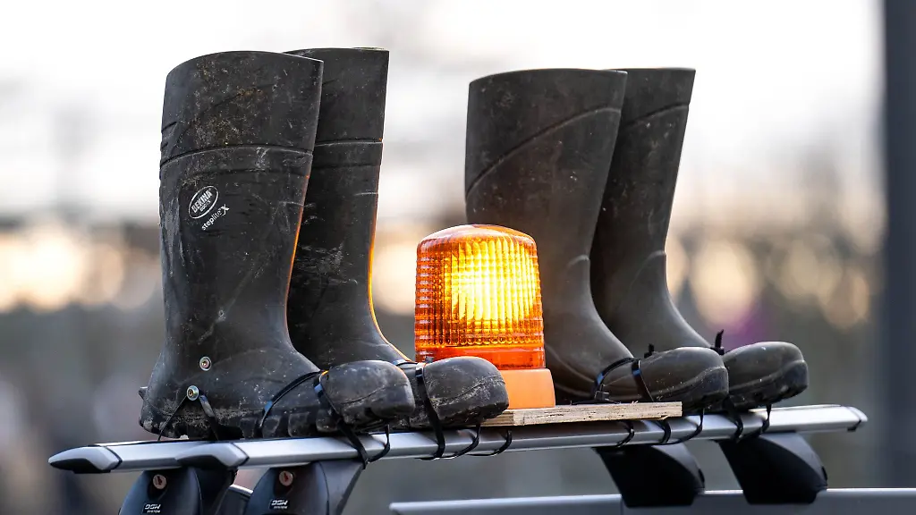 Gummistiefel-und-ein-Warnlicht-auf-dem-Dach-eines-Autos-sind-bei-einer-Demonstration-von-Bauern-zu-sehen